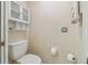 Small bathroom with toilet and wall-mounted shelving at 11447 Golf Round Dr, New Port Richey, FL 34654