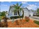 Side view of a light blue house with a two-car garage and landscaping at 11447 Golf Round Dr, New Port Richey, FL 34654