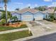 Three-car garage with a well-maintained front yard at 11447 Golf Round Dr, New Port Richey, FL 34654