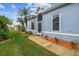 Side view of a light blue house with a screened porch and landscaping at 11447 Golf Round Dr, New Port Richey, FL 34654