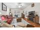 Living room with hardwood floors, red leather couches, and a fireplace at 11447 Golf Round Dr, New Port Richey, FL 34654