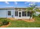 Bright sunroom addition with screened windows and a white door at 11447 Golf Round Dr, New Port Richey, FL 34654