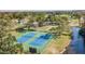 Two tennis courts near a lake in a residential area at 11447 Golf Round Dr, New Port Richey, FL 34654