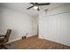 Bedroom with wood-look floors, ceiling fan, and home office setup at 11614 Brighton Knoll Loop, Riverview, FL 33579