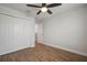 Bedroom with wood-look floors, double door closet, and ceiling fan at 11614 Brighton Knoll Loop, Riverview, FL 33579