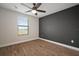 Bright bedroom with wood-look floors, ceiling fan, and large window at 11614 Brighton Knoll Loop, Riverview, FL 33579