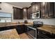 Modern kitchen with granite countertops and dark cabinets at 11614 Brighton Knoll Loop, Riverview, FL 33579