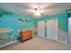 Bedroom with ocean-themed mural, ceiling fan, and double closets at 12127 Luftburrow Ln, Hudson, FL 34669