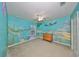 Charming bedroom with ocean-themed mural and built-in dresser at 12127 Luftburrow Ln, Hudson, FL 34669