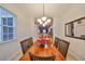 Dining room with a wooden table, chandelier, and views to the kitchen at 12127 Luftburrow Ln, Hudson, FL 34669