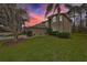 Two-story house with a tan exterior, landscaping, and a sunset view at 12127 Luftburrow Ln, Hudson, FL 34669