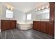 Bright bathroom with a corner bathtub, double vanities, and tile flooring for a luxurious feel at 1236 Live Oak Ln, Lutz, FL 33558