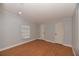 Neutral bedroom features wood-look floors, a window, and two closet doors at 1236 Live Oak Ln, Lutz, FL 33558