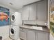 Bright laundry room, stacked washer and dryer, gray cabinets, and a utility sink at 146 4Th Ne Ave # 504, St Petersburg, FL 33701