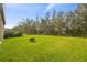 Large backyard with lush grass and fire pit at 14690 Horse Trot Rd, Lithia, FL 33547