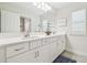 Bathroom with double vanity, white cabinets, and large mirror at 14690 Horse Trot Rd, Lithia, FL 33547