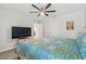 Spacious bedroom with a large bed, mounted TV, and ceiling fan at 14690 Horse Trot Rd, Lithia, FL 33547