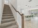 Modern carpeted staircase with wooden handrail at 14690 Horse Trot Rd, Lithia, FL 33547