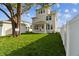 Tan three-story house with covered patio and fenced yard at 1740 W Saint Louis St, Tampa, FL 33607