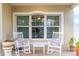 Inviting front porch with rocking chairs and planters at 17436 Lawn Orchid Loop, Land O Lakes, FL 34638