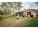 Landscaped backyard with screened patio, grill, and large tree at 19144 Meadow Pine Dr, Tampa, FL 33647