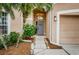 Inviting front entryway with a gray door and landscaping at 19144 Meadow Pine Dr, Tampa, FL 33647