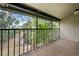 A screened-in balcony overlooks lush greenery and landscaping at 2375 Lake Heather Heights Ct # 202, Dunedin, FL 34698