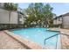 Pool with lounge chairs, maintained landscaping, and trees at 2375 Lake Heather Heights Ct # 202, Dunedin, FL 34698