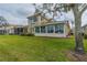 Back exterior showcasing sunroom addition and landscaping at 2431 Kensington Greens Dr # 0, Sun City Center, FL 33573