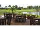 Outdoor patio area with tables and chairs overlooking a pond at 2431 Kensington Greens Dr # 0, Sun City Center, FL 33573