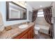 Bathroom with granite countertop and brown wood cabinets at 2893 Allapattah Dr, Clearwater, FL 33761