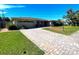 Single story home with a large brick paver driveway at 3182 65Th N St, St Petersburg, FL 33710