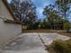 Large backyard with cracked concrete patio and mature trees at 4228 Spring Way Cir, Valrico, FL 33596