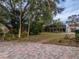 Large backyard with a paved patio area and trees at 4228 Spring Way Cir, Valrico, FL 33596