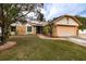 Landscaped front yard with a two-car garage and stone facade at 4228 Spring Way Cir, Valrico, FL 33596