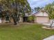 House exterior featuring stone accents, solar panels, and a well-maintained lawn at 4228 Spring Way Cir, Valrico, FL 33596