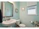 Light teal bathroom with pedestal sink and toilet at 4449 Tour Trce, Land O Lakes, FL 34638