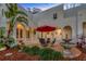 Inviting patio with fountain, seating area, and red umbrella at 4845 W Sunset Blvd, Tampa, FL 33629