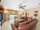 Living room with leather furniture, a large TV, and sliding doors to the patio at 5537 Terrain De Golf Dr, Lutz, FL 33558