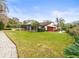 Landscaped backyard with a large grassy area and paved walkway at 5649 Glencrest Blvd, Tampa, FL 33625