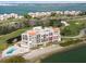 Aerial view of waterfront condo building with pool and private beach access at 5700 Escondida S Blvd # 302, St Petersburg, FL 33715