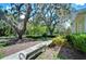 Landscaped front yard with a walkway, lush greenery, and a park bench at 6120 Watercolor Dr, Lithia, FL 33547