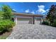 Two-car garage with paver driveway and landscaping at 6120 Watercolor Dr, Lithia, FL 33547