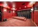 Home theater with red walls, raised platform, and projector screen at 6408 Bright Bay Ct, Apollo Beach, FL 33572