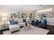 Living room with sectional sofa, two armchairs, and hardwood floors, featuring natural light at 674 61St S Ave, St Petersburg, FL 33705