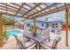 Pergola-covered patio with dining area near pool at 674 61St S Ave, St Petersburg, FL 33705