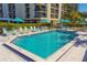 Community pool with lounge chairs and umbrellas at 690 Island Way # 410, Clearwater Beach, FL 33767