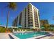 Resort-style pool and building exterior with lush landscaping at 690 Island Way # 410, Clearwater Beach, FL 33767