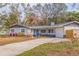 Charming ranch home with gray exterior, blue door, and landscaped yard at 7000 Dr Martin Luther King Jr S St, St Petersburg, FL 33705