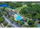 Aerial view showing clubhouse, pool, and surrounding landscape at 7304 Cleopatra Dr, Land O Lakes, FL 34637